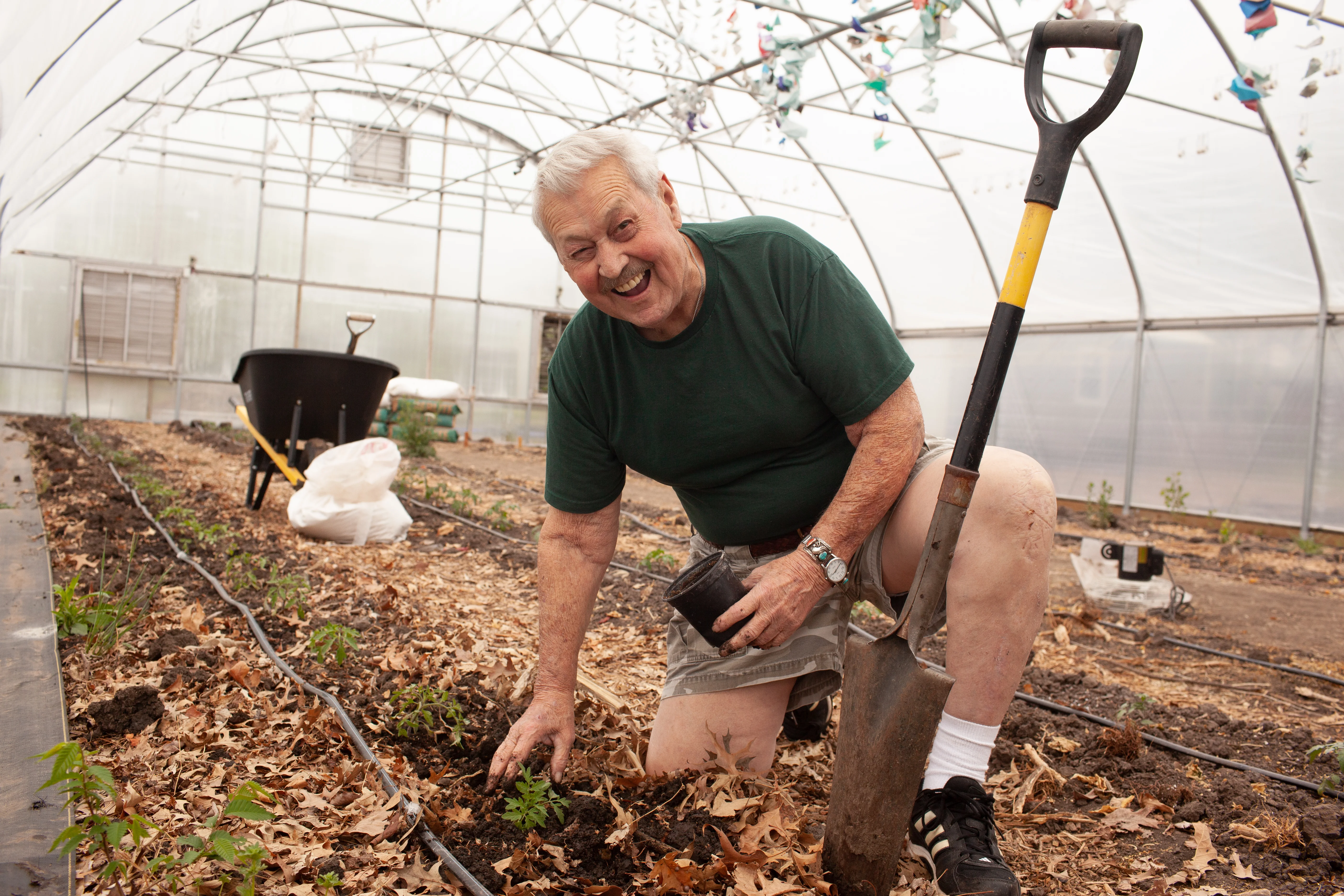um homem plantando plantas e sorrindo