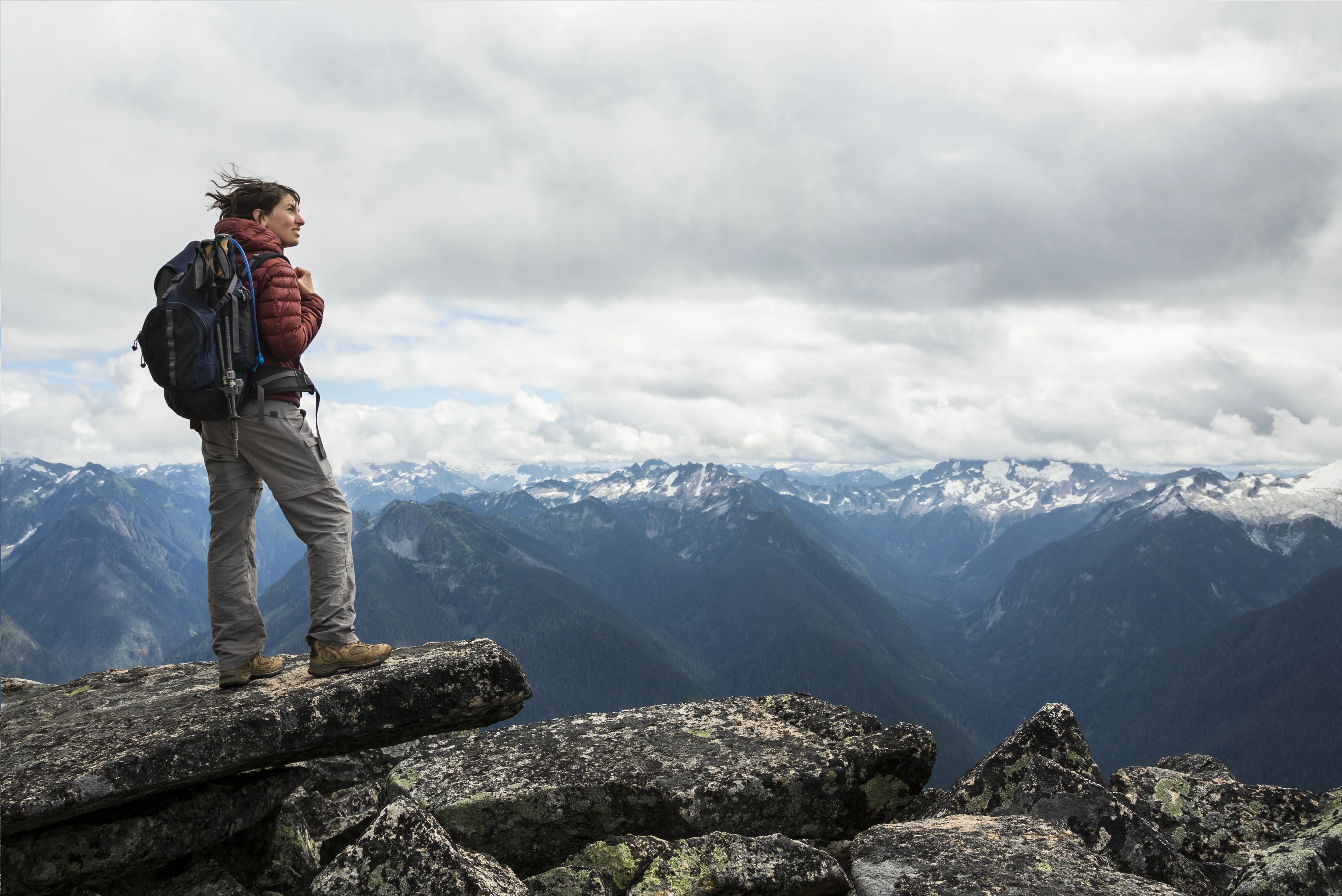 a man standing on a rock overlooking a mountain range