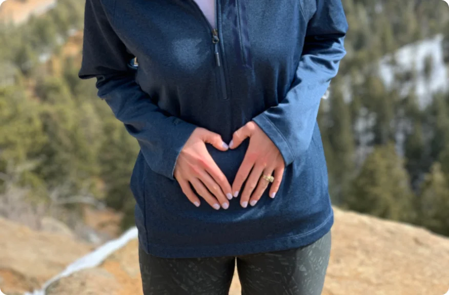 Eine Frau, die mit den Händen auf dem Bauch steht, steht für die Möglichkeit bedeutungsvoller und erfüllender intimer Begegnungen nach einer Stomaoperation.