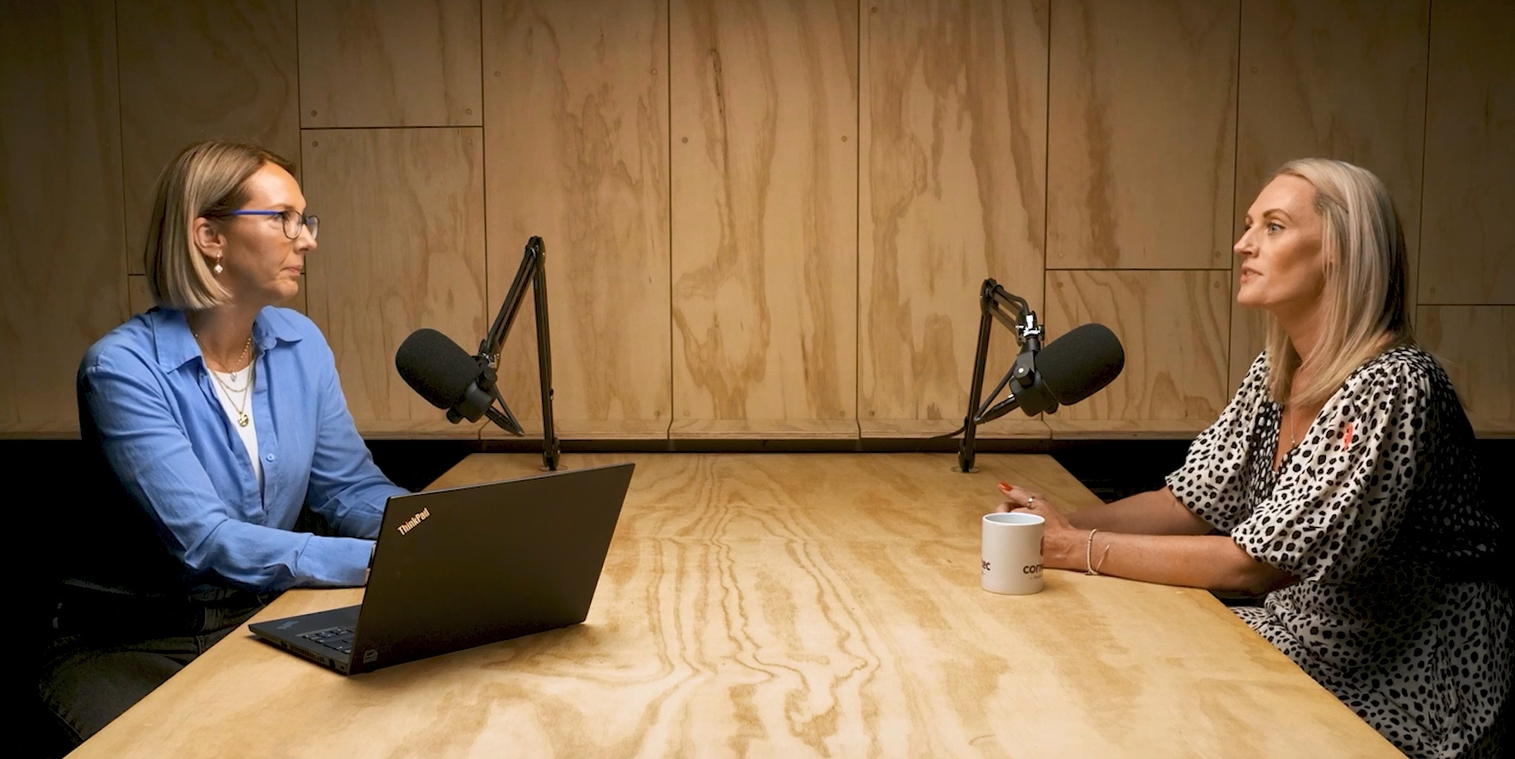 a woman and a woman sitting at a table with a laptop